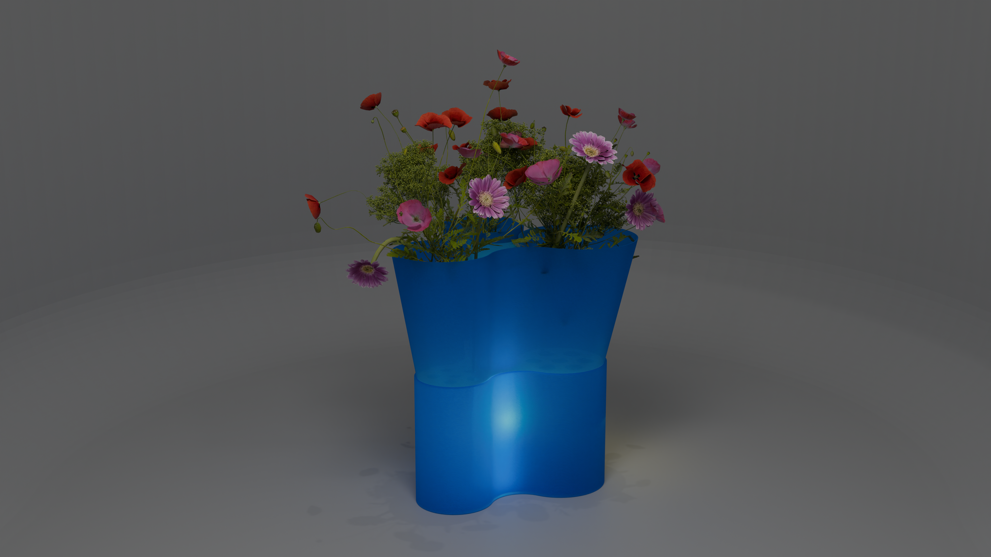 Paso Glo vase, a dual-sectioned blue coloured planter with a glowing base, holding red and pink flowers.