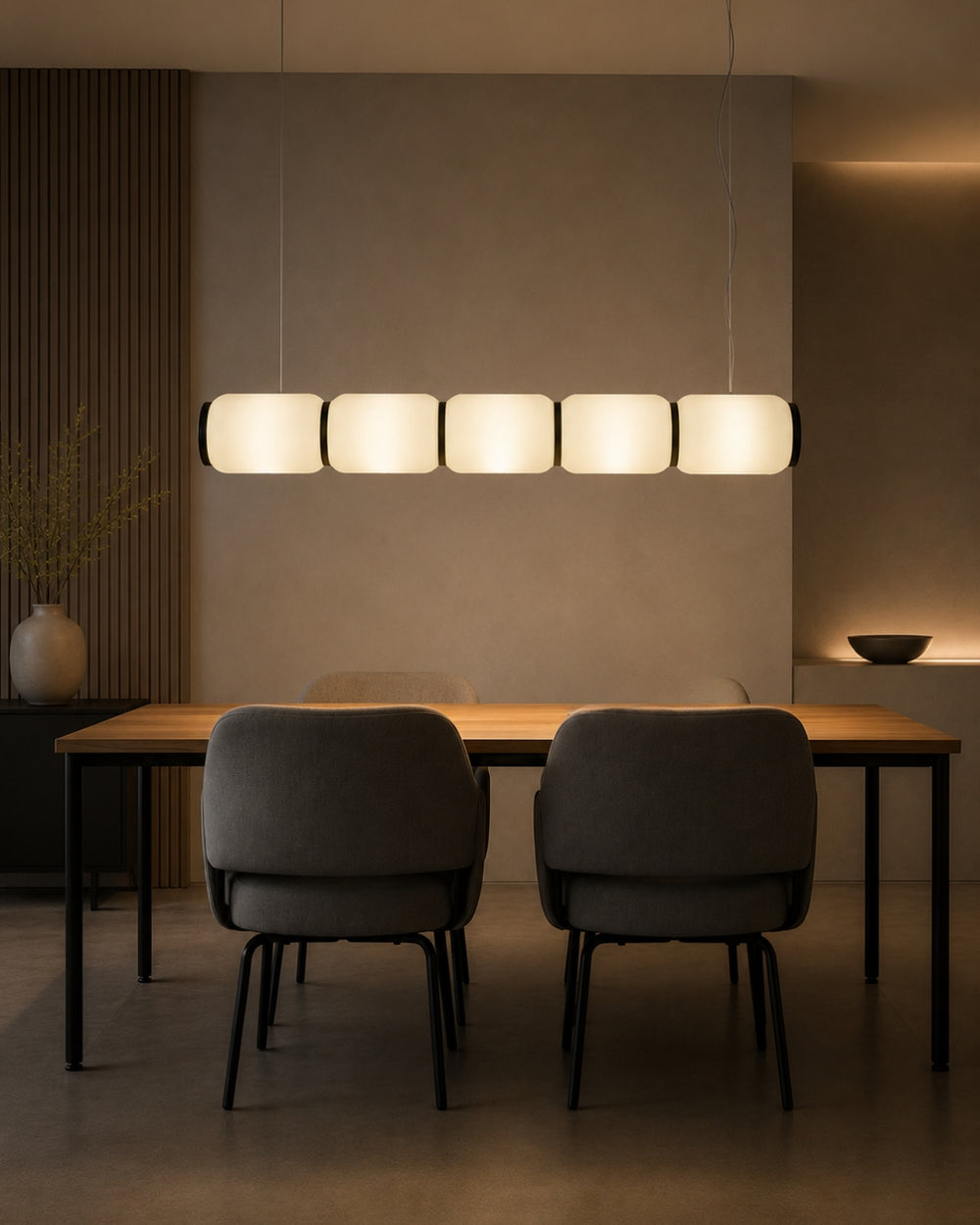 A suspended Bello H hanging lamp casting a diffused, warm horizontal glow through its five connected, translucent glowing sections, beautifully contrasted by dark dividing bands and end caps.
