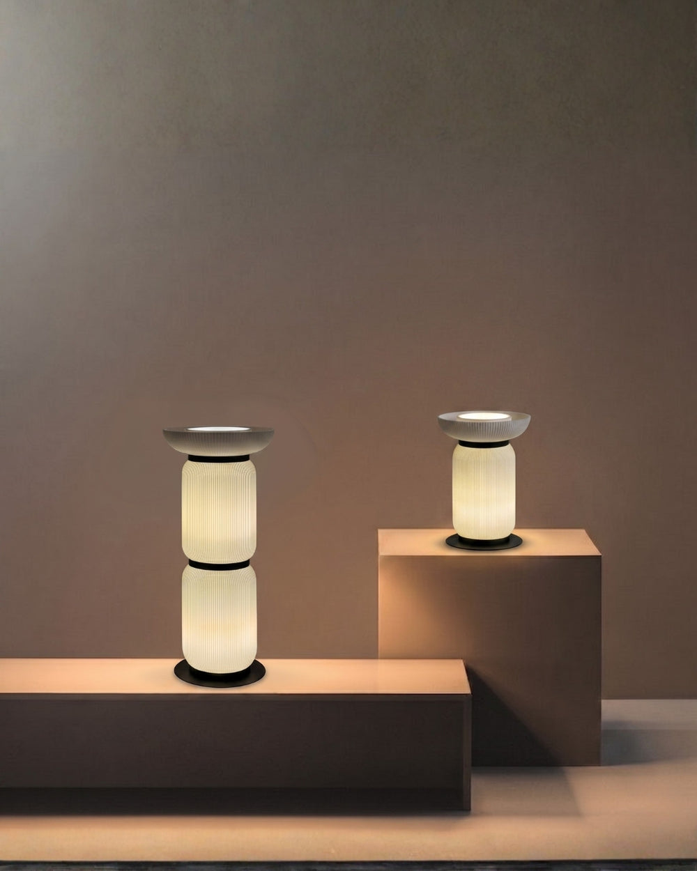 Soft ambient lighting provided by two Bello Table Series lamps, casting a warm and inviting glow across a modern, gallery-style display space.