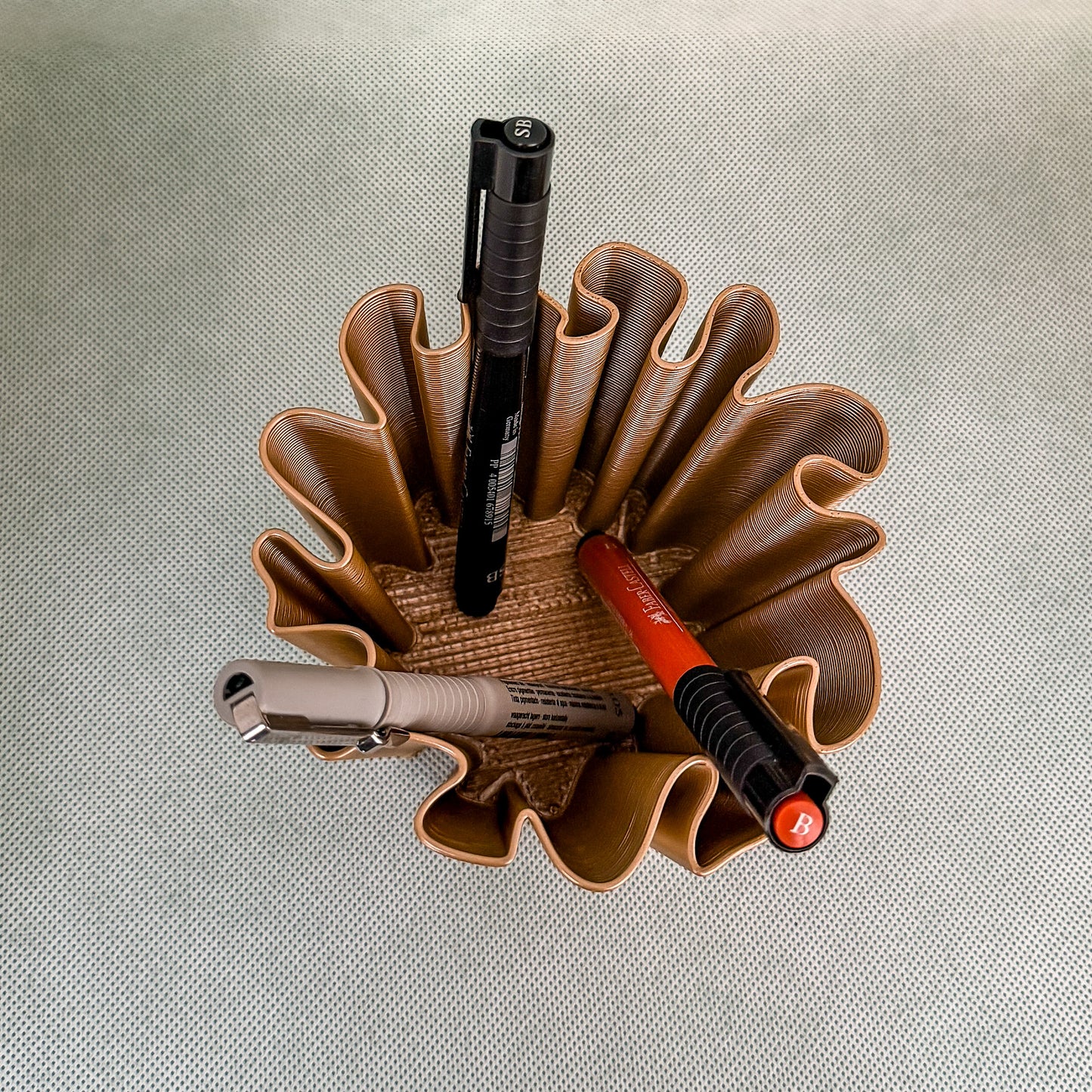 top view of coral vase with pens in bronze color
