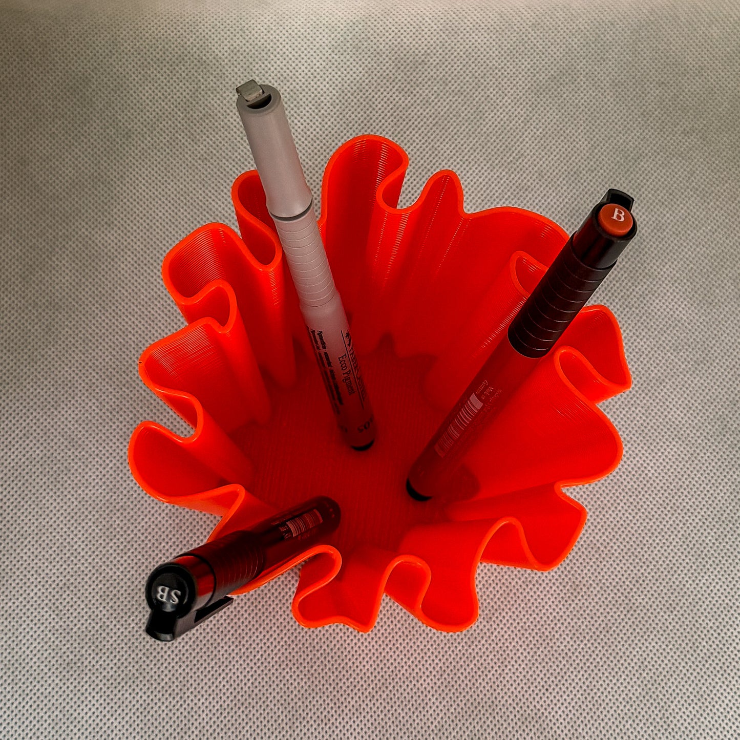 top view of coral vase with pens  in red color