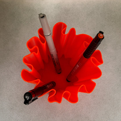 top view of coral vase with pens  in red color