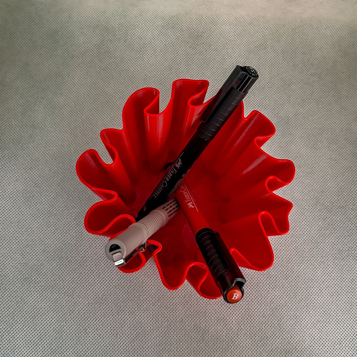 top view of coral vase with pens in red color