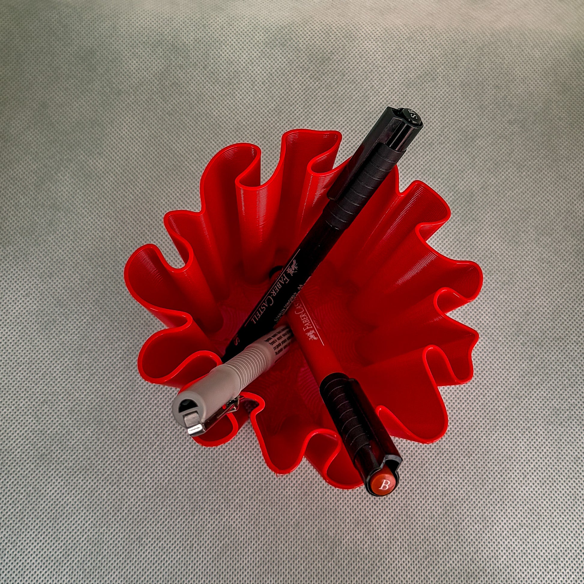 top view of coral vase with pens in red color