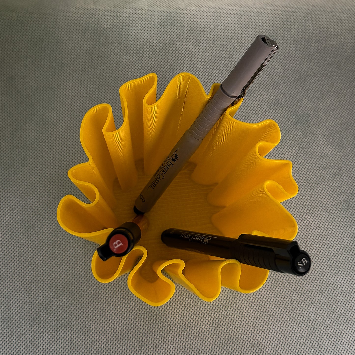 top view of coral vase with pens in yellow color