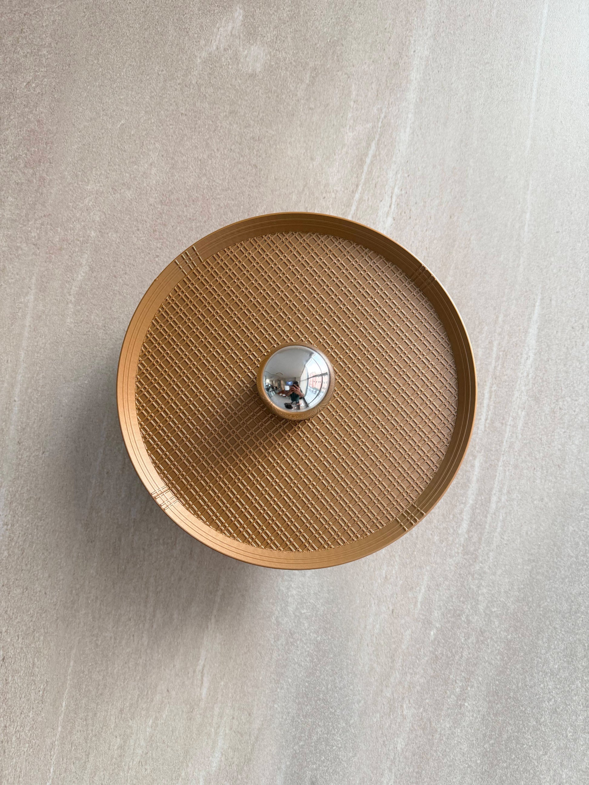 Off shot of Ora wall light with textured surface and a reflector bulb on a gray background