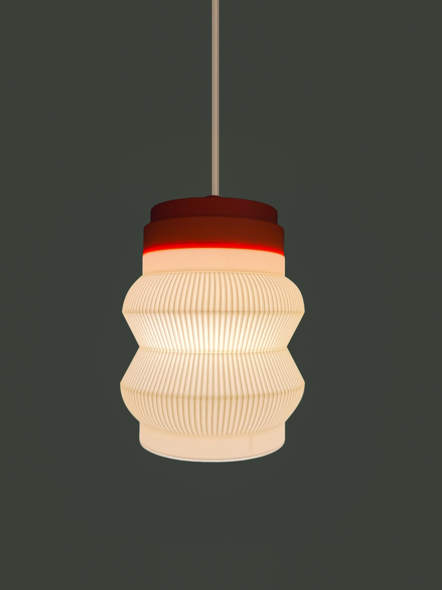 On shot of orange base Stacko drop Pendant light on a dark background
