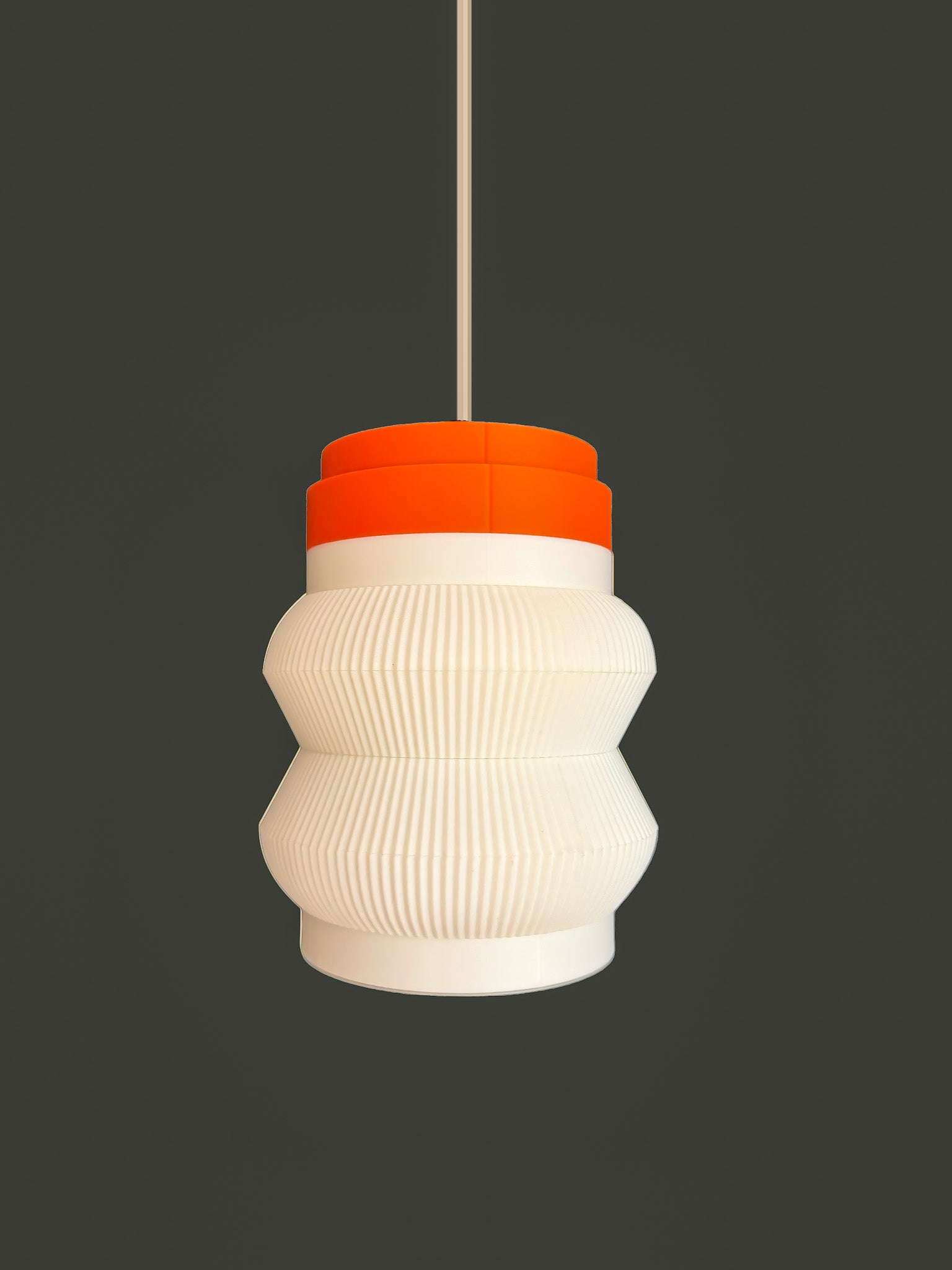 Off shot of orange base Stacko drop Pendant light on a dark background